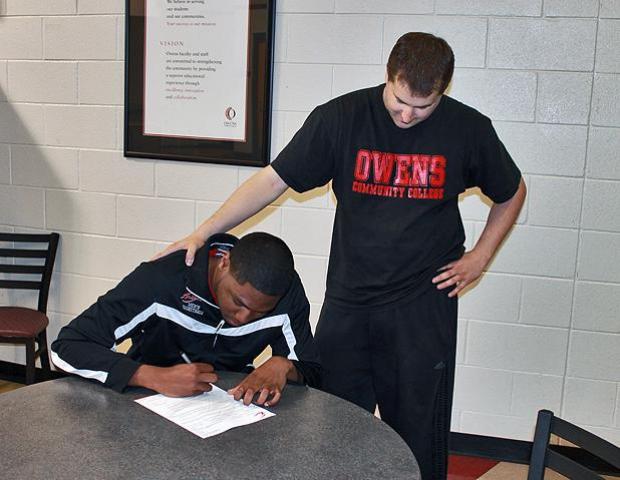 Franklin Lindsey signs his letter of intent to play for Indiana Tech University as Express head coach Dave Clarke looks on. He is the fifth player from last year's team to move on to a four-year school. Photo by Nicholas Huenefeld/Owens Sports Information