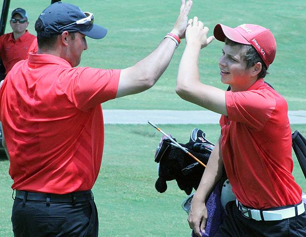 Express men's golf head coach Josh Williams (left) gives Luke Berger some dap after the ninth hole, a hole in which Berger made a difficult par save. He finished at 3-under 69 today. Photo by Nicholas Huenefeld/Owens Sports Information