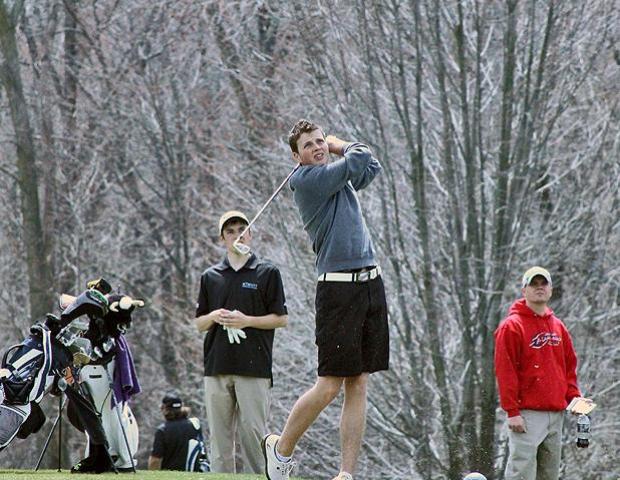 Luke Berger watches one of his tee shots today as Express men's golf assistant coach Ryan Brown watches in the far right. Photo by Nicholas Huenefeld/Owens Sports Information