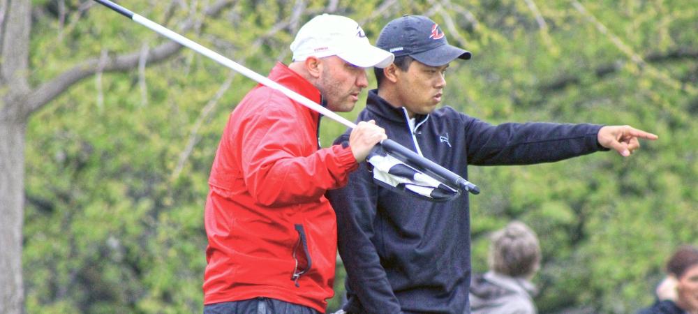 Bandit Chaisuk and head coach Josh Williams discuss a play on the green during a recent tournament. Photo by Nicholas Huenefeld/Owens Sports Information