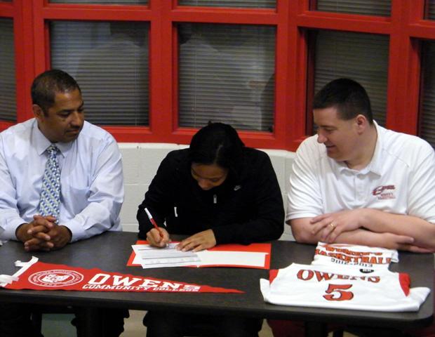 Kamilah Carter, center, signs her letter of intent to play for the Express next year as Express women's basketball head coach Michael Llanas, left, and assistant basketball coach Stephen Perry, right, look on. Photo courtesy of Nicholas Huenefeld/Owens Sports Information