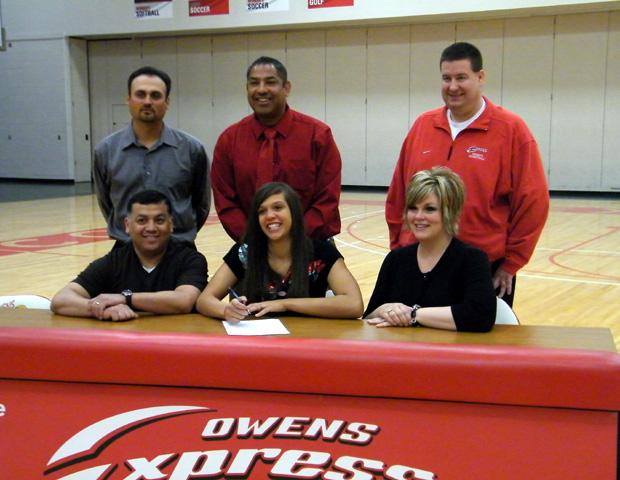 Express center Hailey Galvan, front center, signs her letter of intent to play at Marian University in Indianapolis, IN. To her right and left are her parents, Roel and Dana Galvan. In the back row, left to right, is Marian head women's basketball coach Todd Bacon, Express women's basketball head coach Michael Llanas, and Express women's basketball assistant coach Stephen Perry. Photo by Nicholas Huenefeld/Owens Sports Information