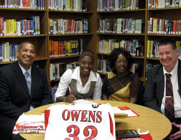 Taylor Marks, second from left, signs her letter of intent. To her right is Michael Llanas, Express women's basketball head coach, and to her left is her mother, Mirium, and Express women's basketball assistant coach Stephen Perry. Photo courtesy of Owens Sports Information