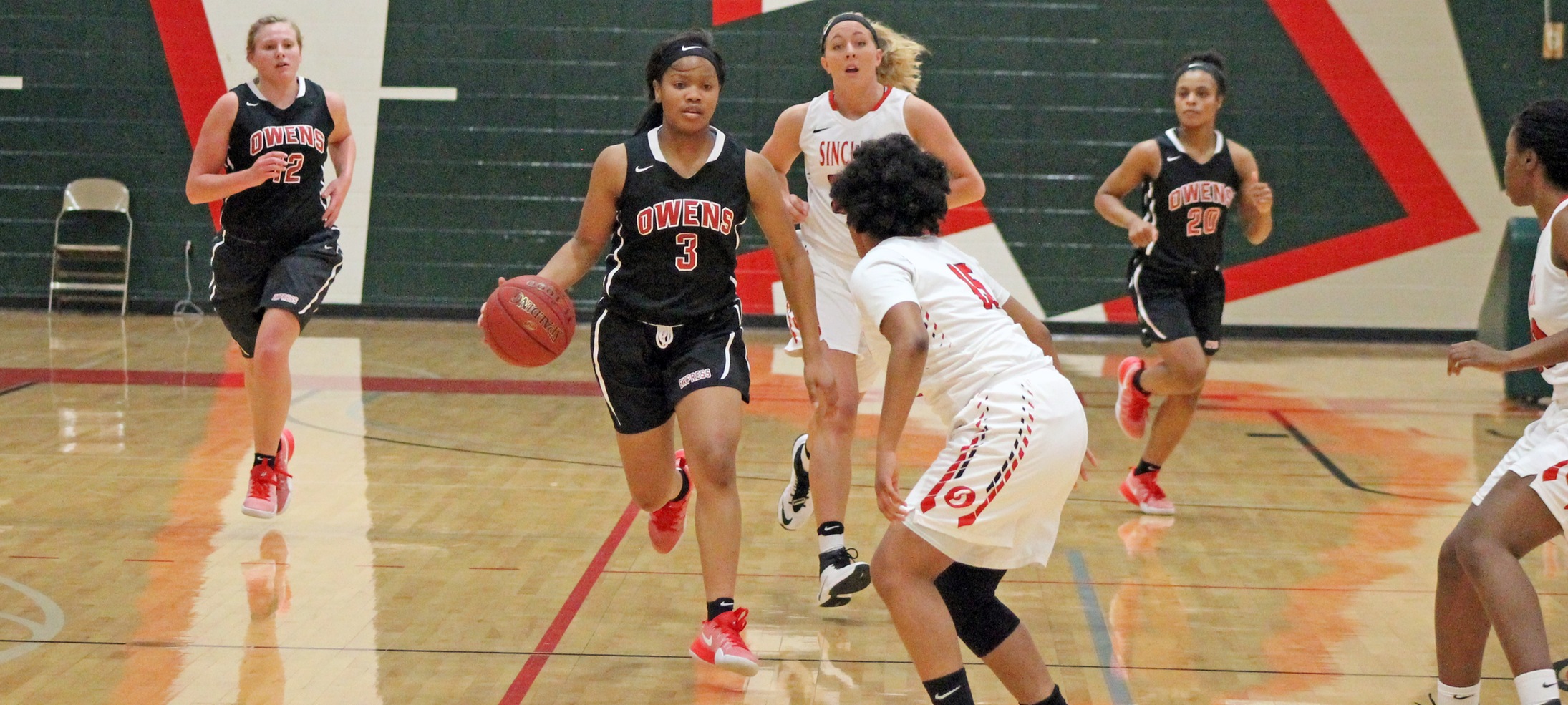 Essence Cowan is pictured bringing the ball up the court with Haili Mossing (L) and Sybil Roseboro (R) just behind. Photo by Nicholas Huenefeld/Owens Sports Information