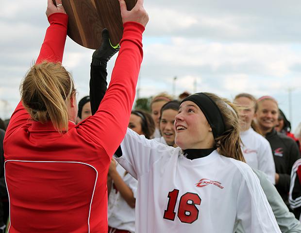 Elizabeth Theaker, right, grabs the Region XII championship plaque from head coach Mary Whisler following today's win. Photo by Nicholas Huenefeld/Owens Sports Information