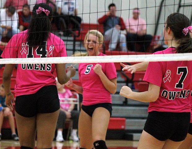Jessica Cooper (5) celebrates a point with Jazmine Thomas (14) and Bailey Dangler (7) in tonight's straight set win over Cuyahoga Community College. Photo by Nicholas Huenefeld/Owens Sports Information