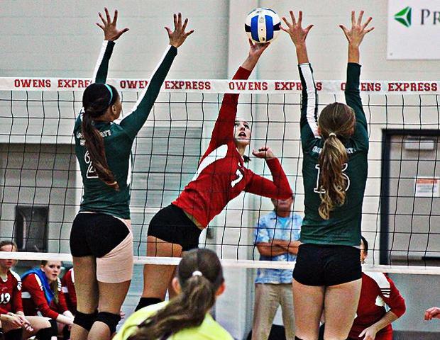 Ally Mikesell attempts a kill through a pair of Cincinnati State blockers. Photo by Nicholas Huenefeld/Owens Sports Information