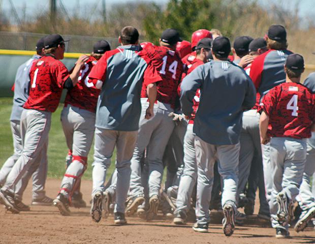 Austin Legate (not seen) is mobbed by his teammates after his walk off RBI single in today's first game. Photo by Nicholas Huenefeld/Owens Sports Information